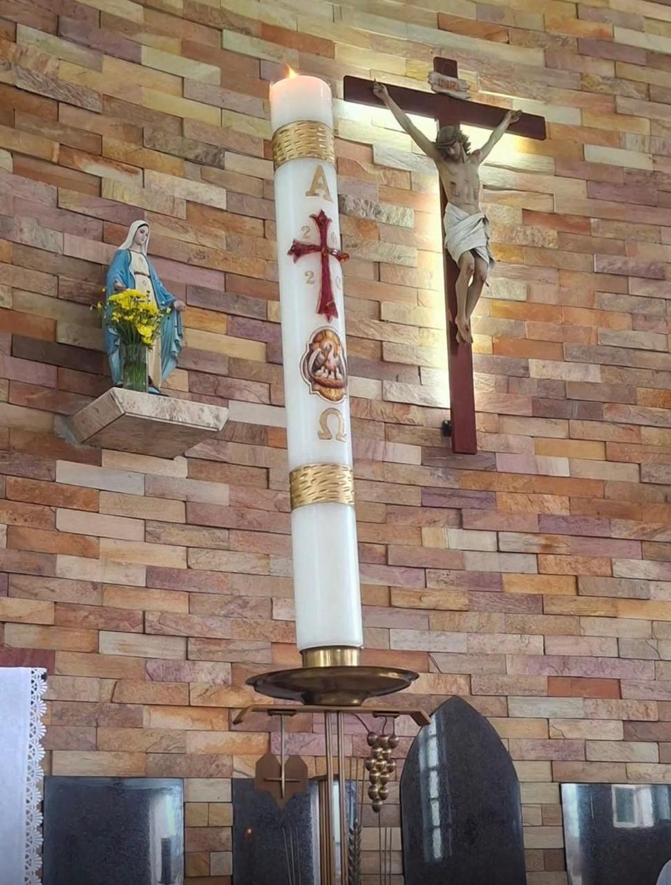 Vela litúrgica acesa no altar de uma igreja